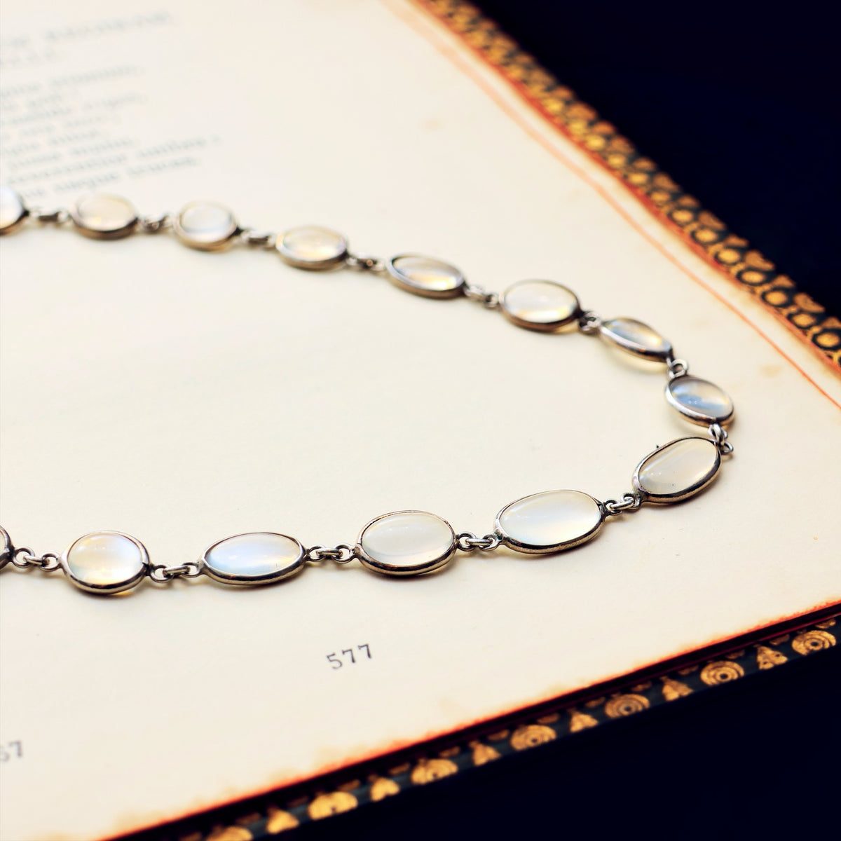 Necklace with moonstone stones on an ornate book