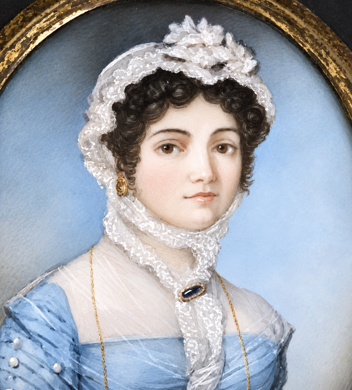 A classical portrait painting of a woman in a light blue dress and white lace bonnet, framed by a gold oval border against a blue background. Wearing a long guard chain and fichu brooch. 
